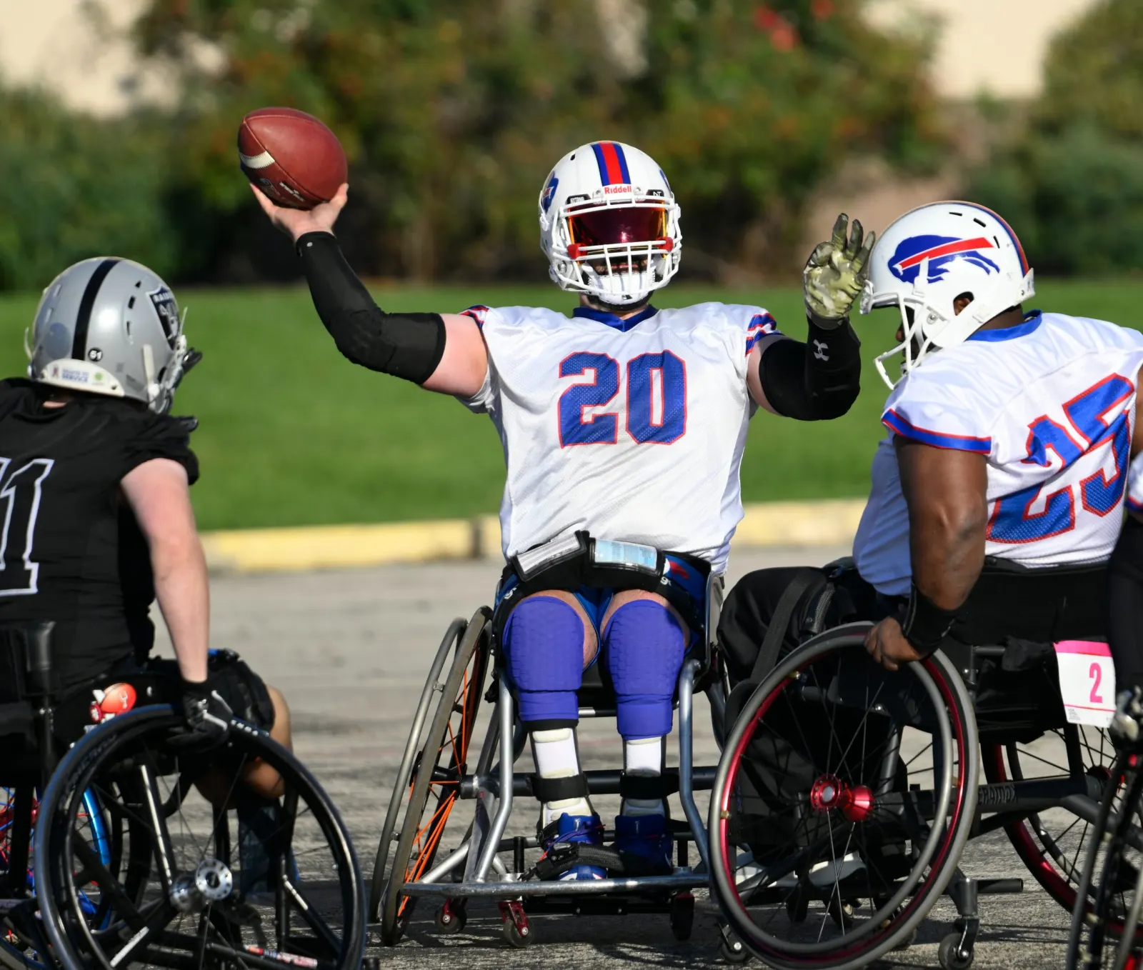A Buffalo Bills player in a white number 20 jersey rears back to throw the football between two defenders.