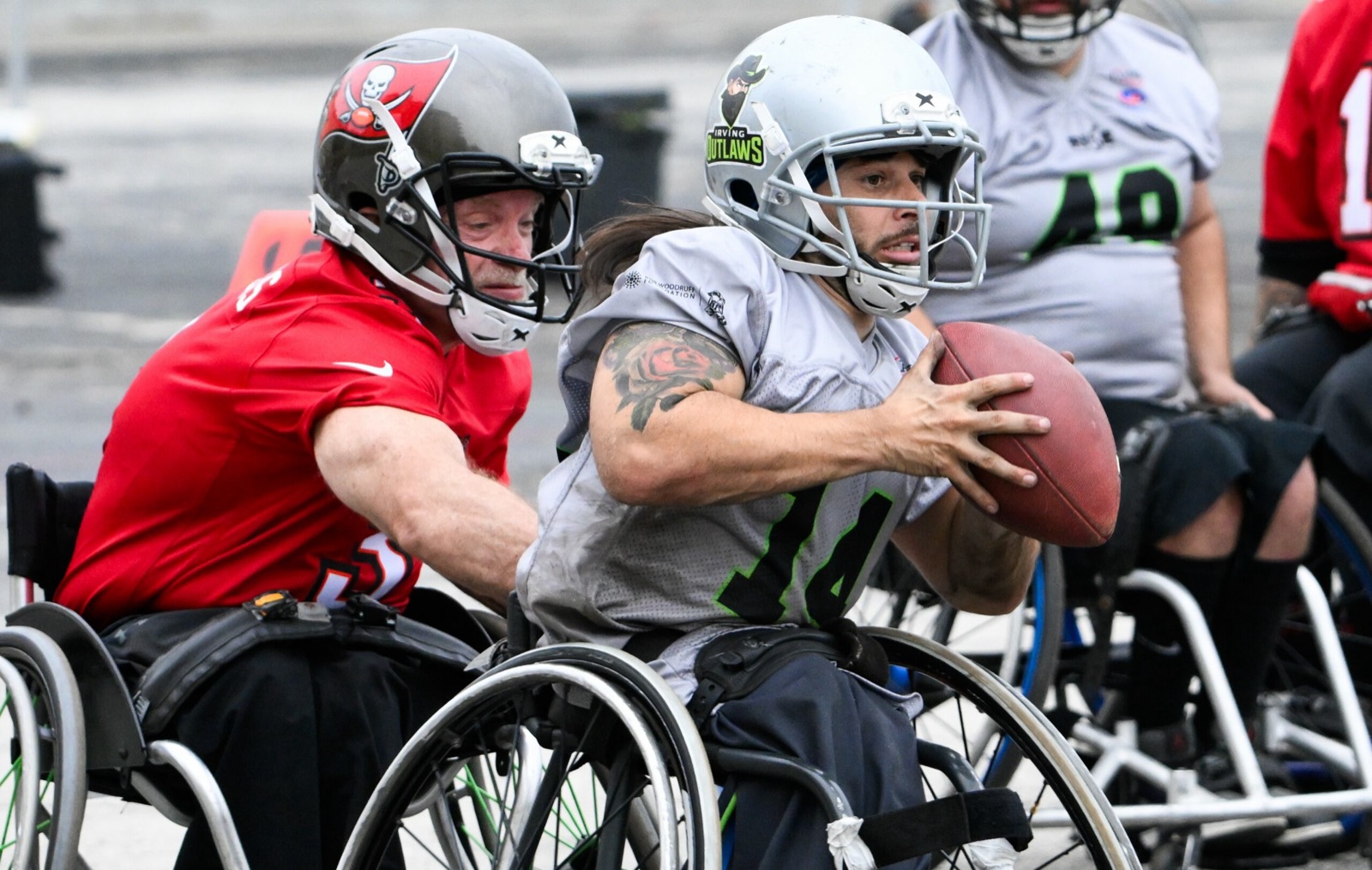 A Tampa Bay Buccaneers defender grabs an Irving Outlaws ballcarrier from behind as he secures the football.